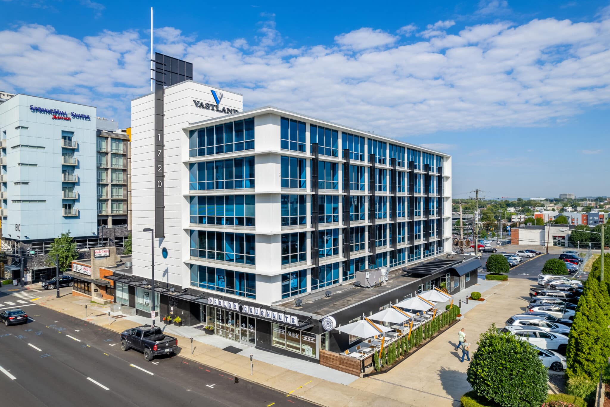 The vastland building with cars parked below.